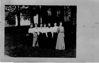 Left to right: Grace Morse Pike, Cora Lance, Emma Tucker, Nellie Williams, Agnes Warren Marsh, May Ormsbee, Grace Kimball. Taken in front of M.E. Church and…